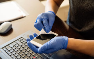 A person cleaning off volatile organic compounds off of their phone.