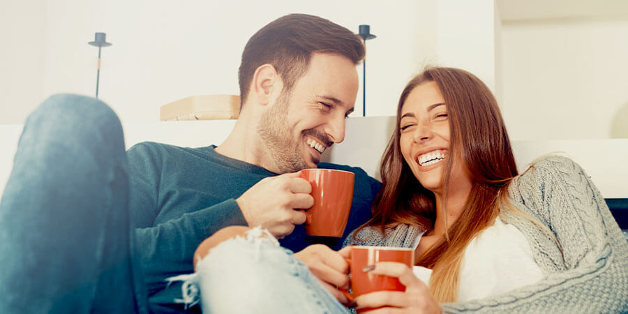 Happy couple relaxing on the couch laughing together