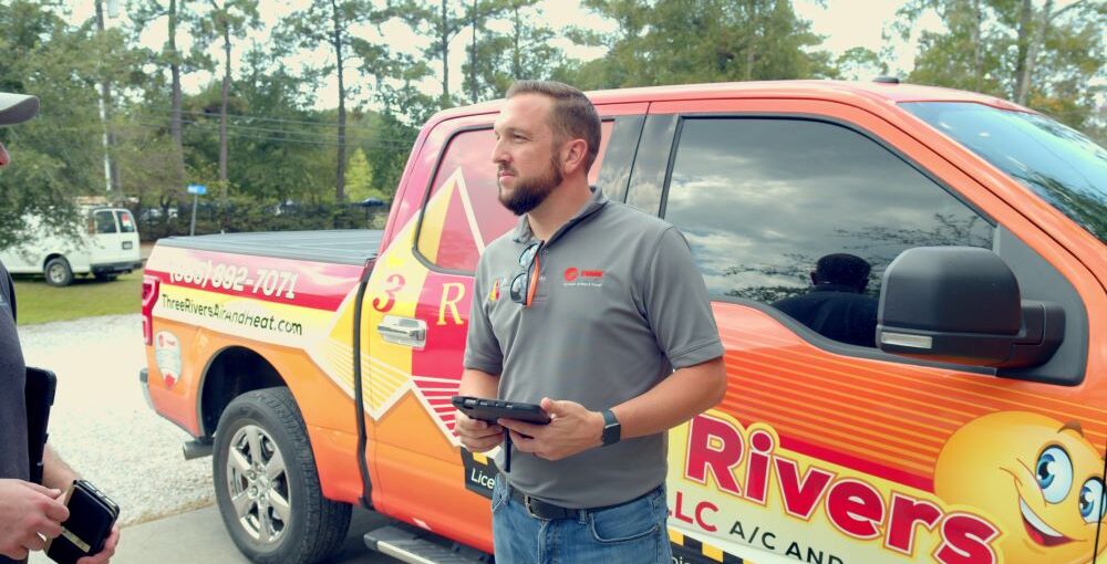 tech outside of branded van with clipboard